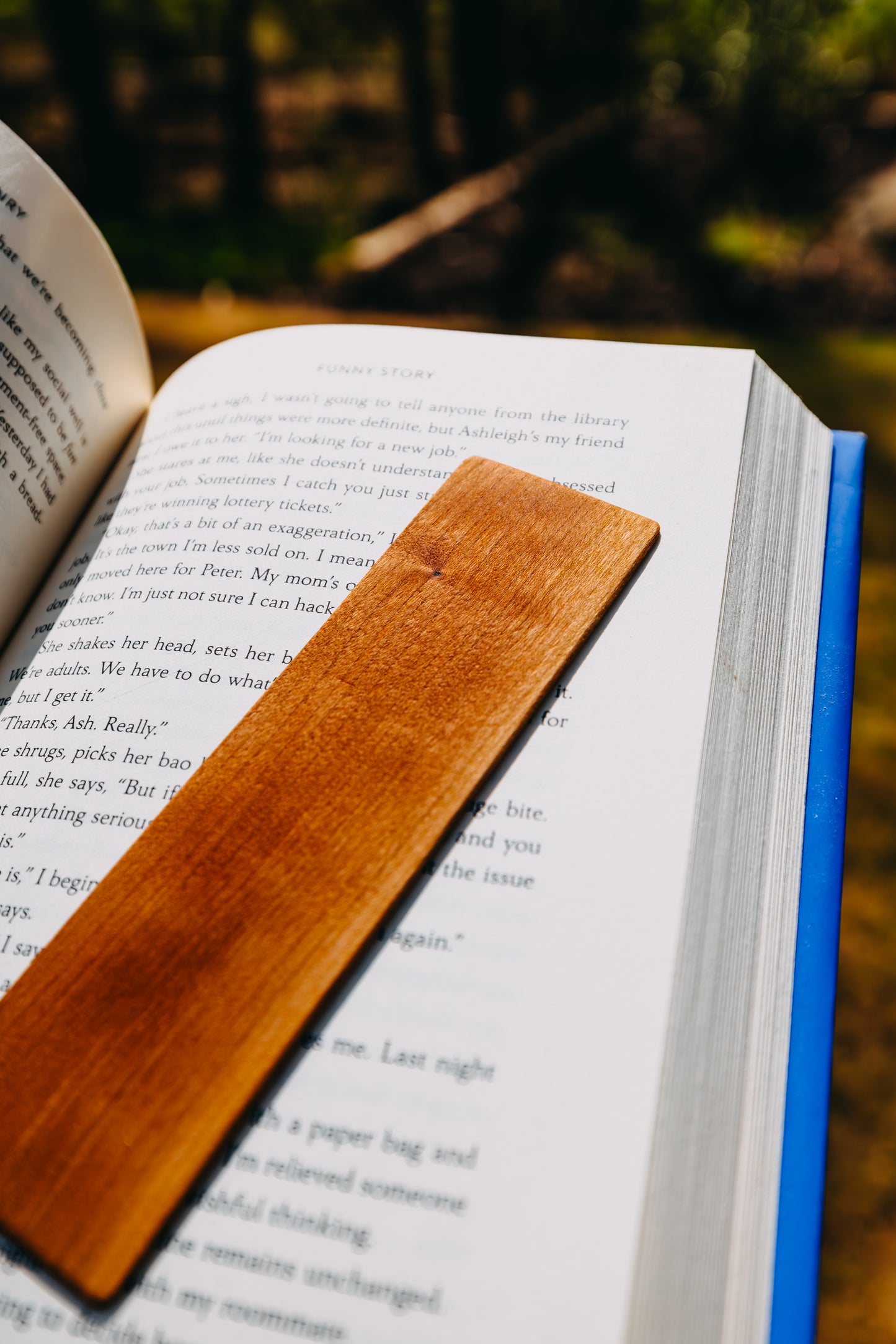 Open book with a wooden cherry edge grain bookmark on a natural background