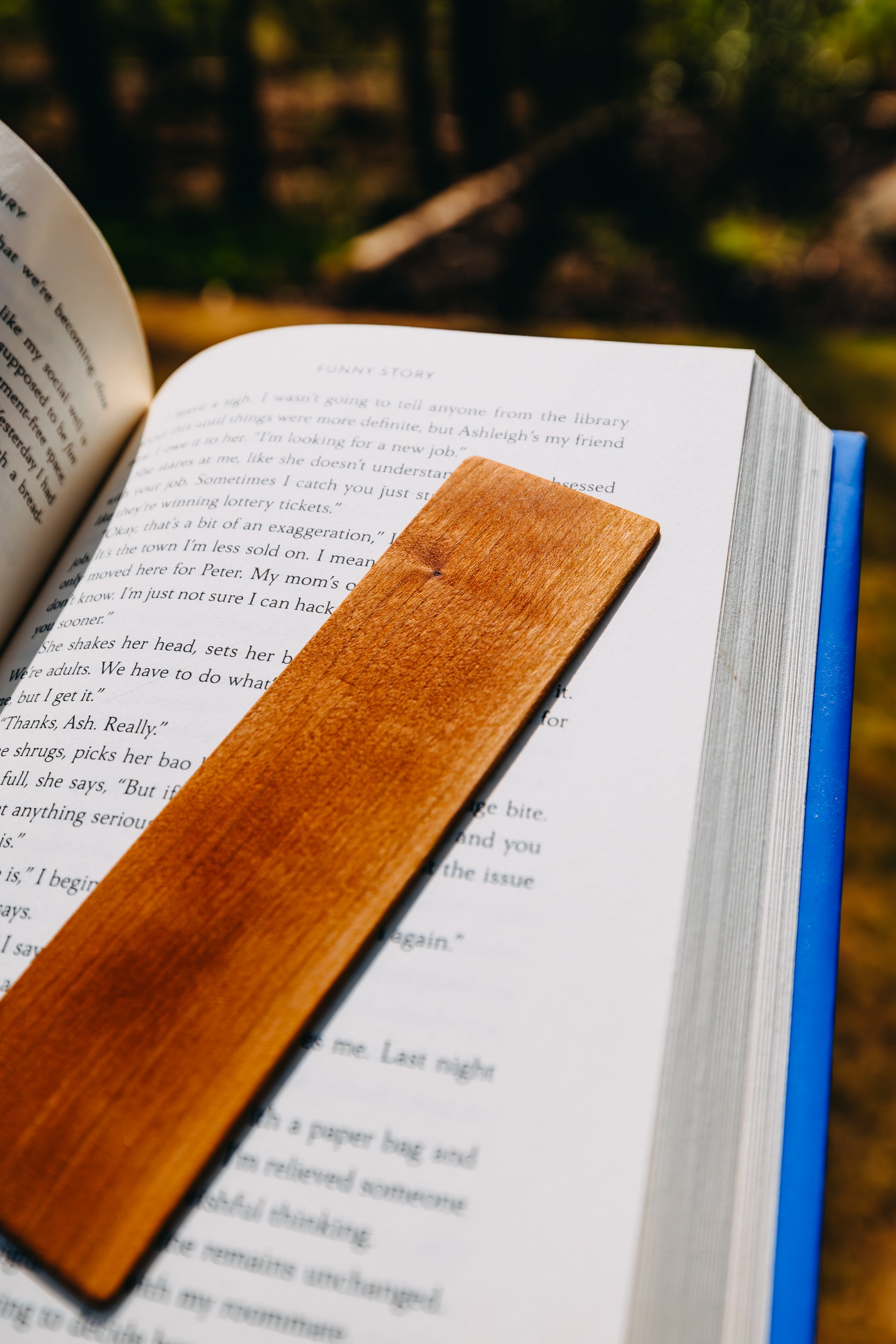 Open book with a wooden cherry edge grain bookmark on a natural background
