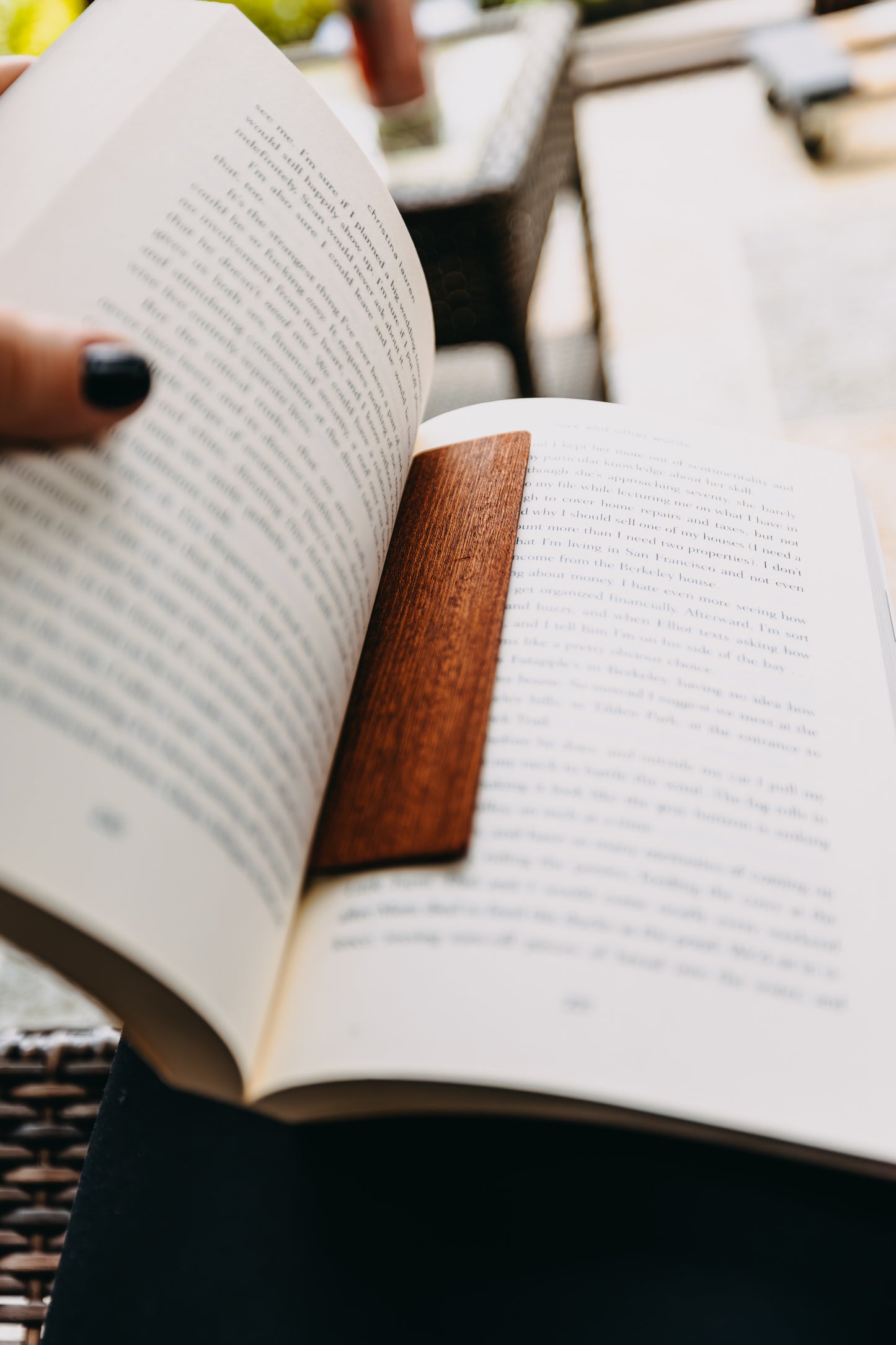 Open book with a wooden sapele edge grain bookmark on a blurred background