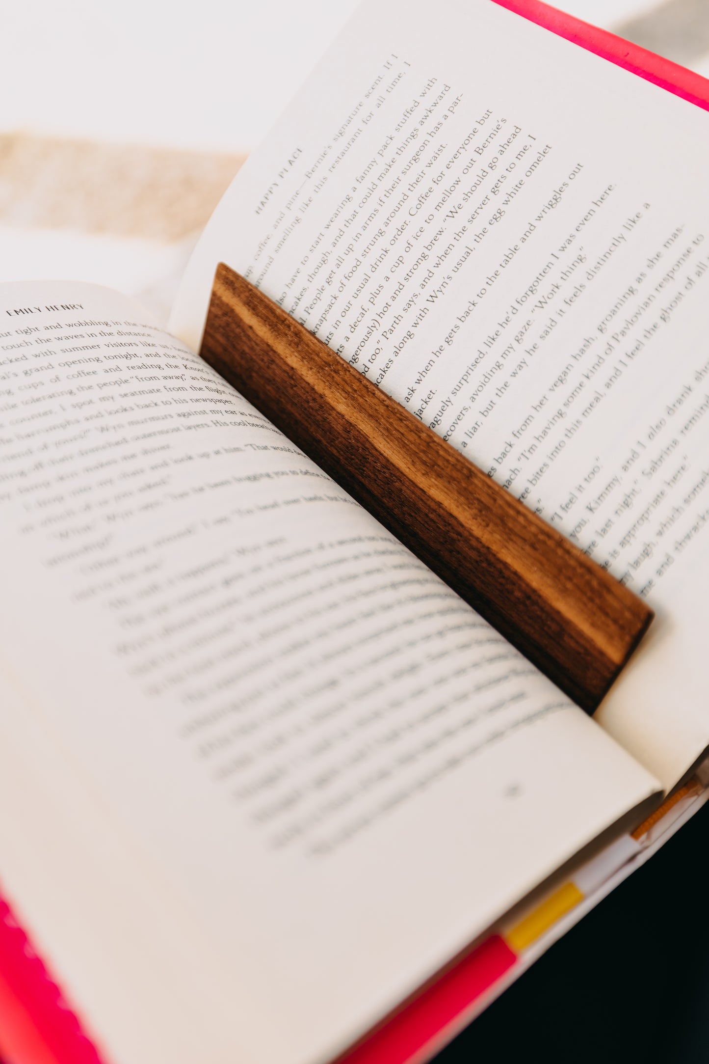 Open book with a wooden black walnut edge grain bookmark on a white background