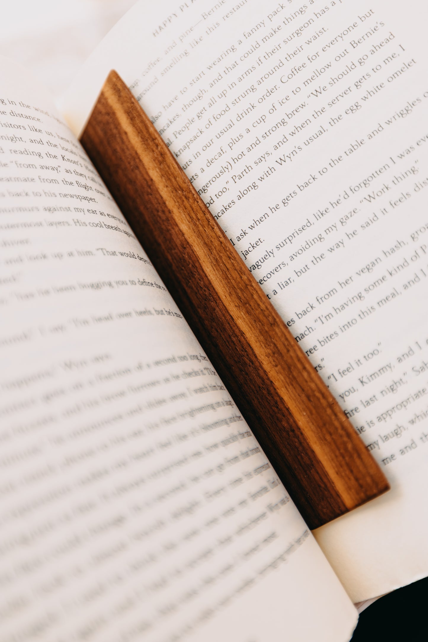 Wooden black walnut edge grain bookmark on an open book