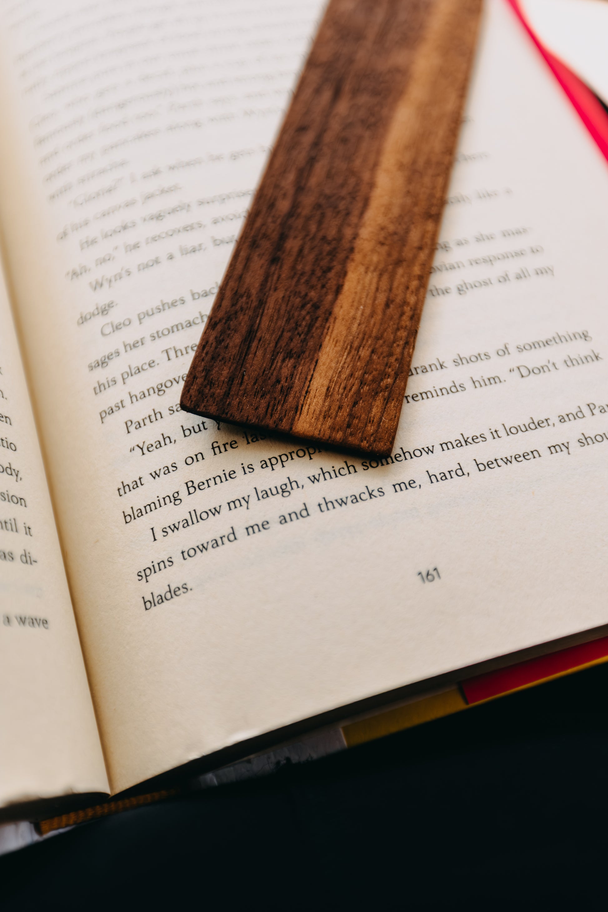 Wooden black walnut edge grain bookmark on an open book